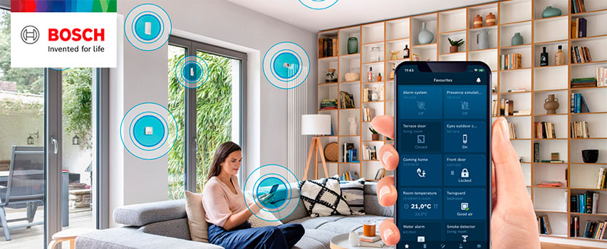 Bosch Smart Home-app viser favoritter som alarm, dører, romtemperatur og røykvarsler i smart hjem med kvinne i sofa
