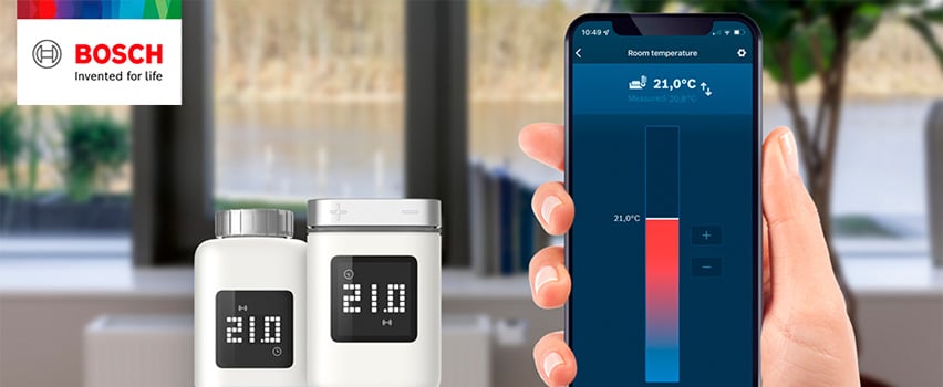 Bosch Smart Home radiatortermostat II med display på 21°C styres via Bosch Smart Home-app på smarttelefon