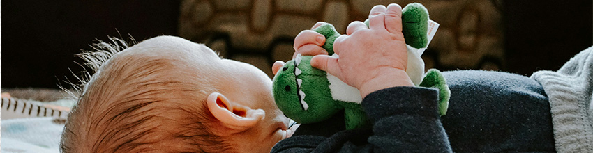 Guttebaby med kosedyr i hendene, gaveidé til gutter som innbyr til lek og trygghet.