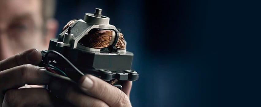 Hånd holder Vitamix blendermotor med synlige kobberviklinger som demonstrerer robust kvalitet og holdbarhet