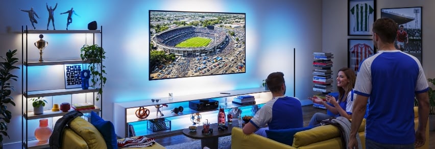 Venner reagerer på rødt kort på TV med dramatisk rød WiZ Sports Live-belysning i stuen