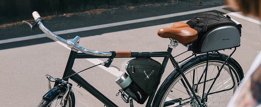 Vintage-sykkel med Wozinsky sadelveske og rammeveske parkert på solrik gate – sykkeltilbehør for touring