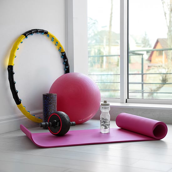 Wozinsky sport- og fitnessutstyr med rosa yogamatte, ball, hulahopring, skumrulle og drikkeflaske ved vinduet