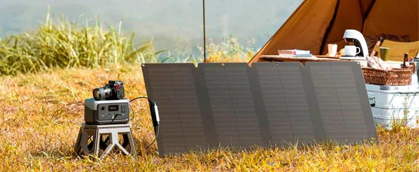 EcoFlow RIVER 2 kraftstasjon og solcellepanel stilt opp ved telt på eng – kompakt off-grid energiløsning til camping